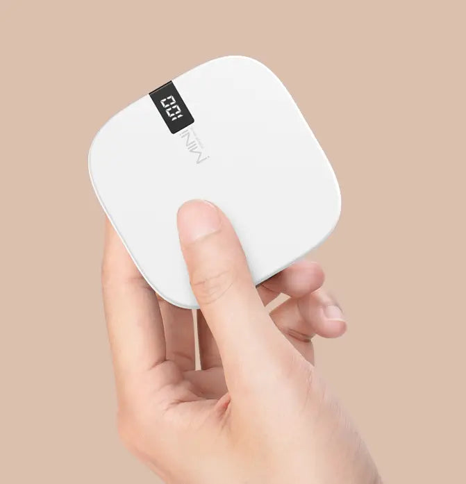 White square digital scale power bank with black display showing 0.21 and mini brand name below, featuring a slim design and 10000mAh capacity in a mini power bank.