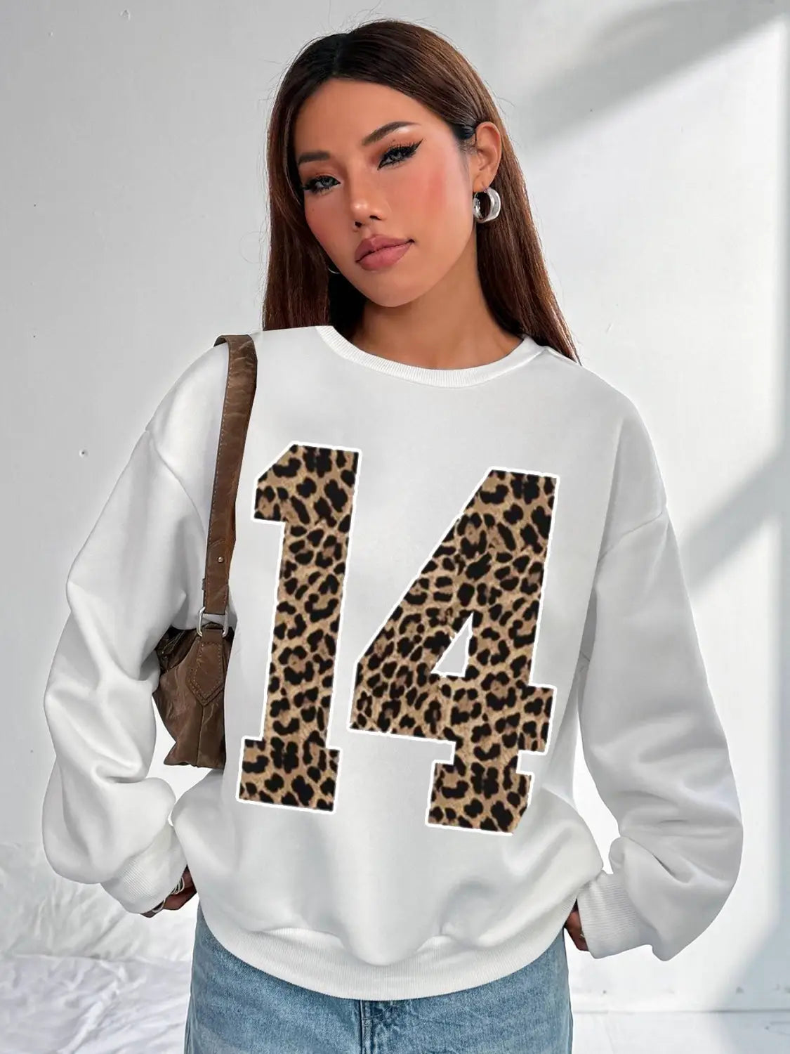 white crew neck sweatshirt showing the back side with a bold leopard print number 14 design