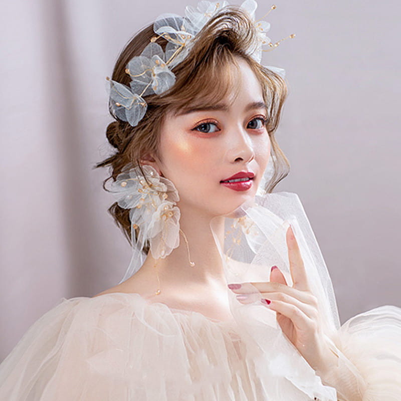 Delicate white tulle flower headband earring set featuring a floral headpiece adorned with sheer fabric and gold accents.