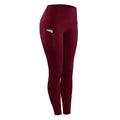 Maroon women compression skinny leggings with high waist and side pocket holding a phone for fitness use