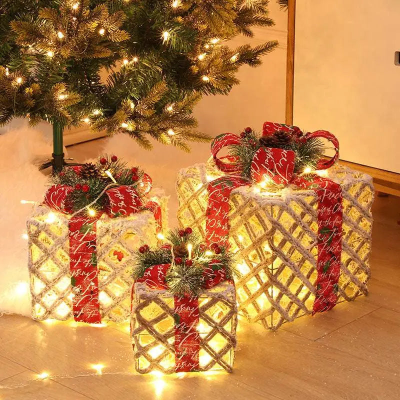 Three illuminated warm white led christmas wrought iron gift boxes with plaid ribbons and pinecone accents