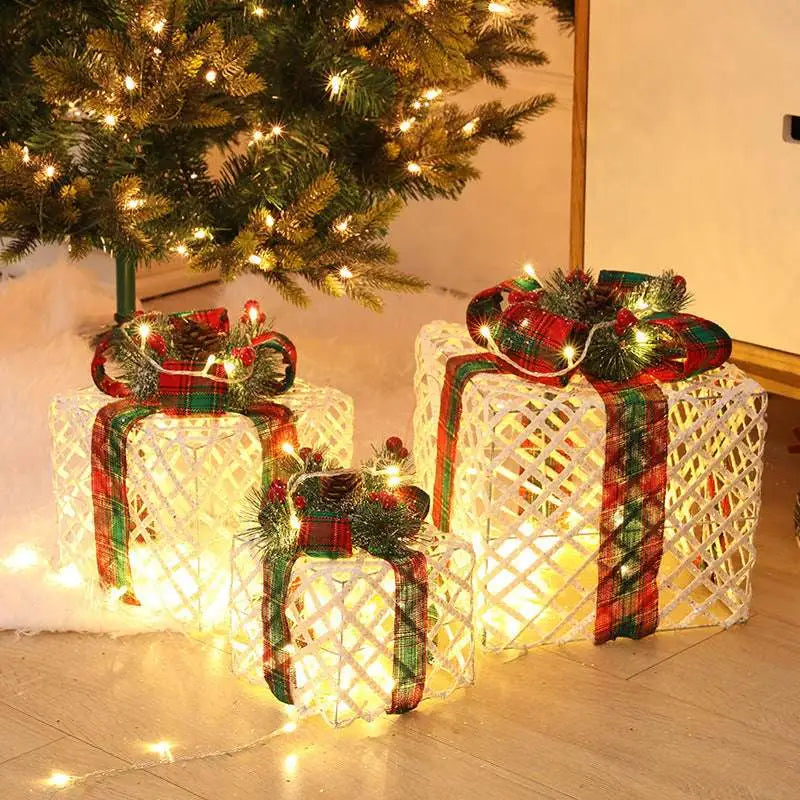 Three illuminated warm white led christmas wrought iron gift boxes with plaid ribbons and pinecone accents