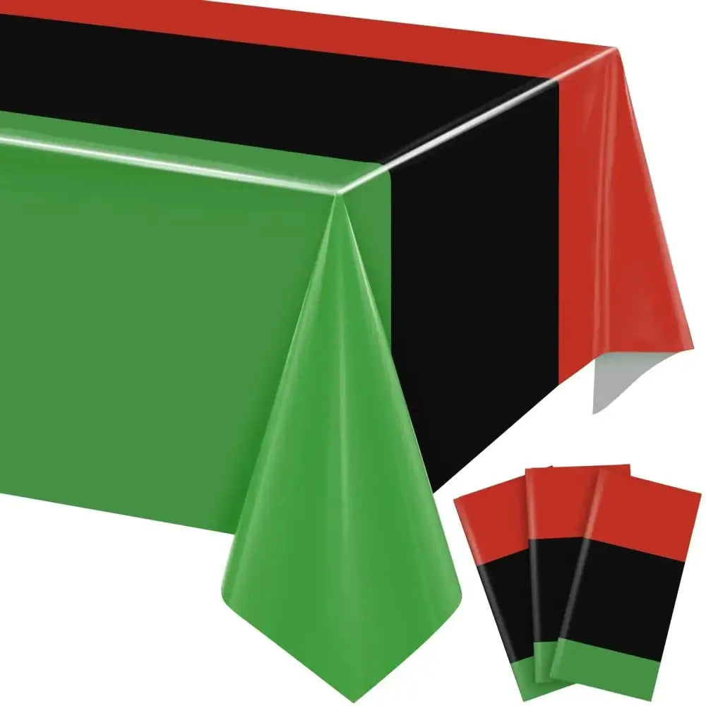 Three pieces juneteenth table cloths with napkins made of green black and red striped plastic for festival atmosphere