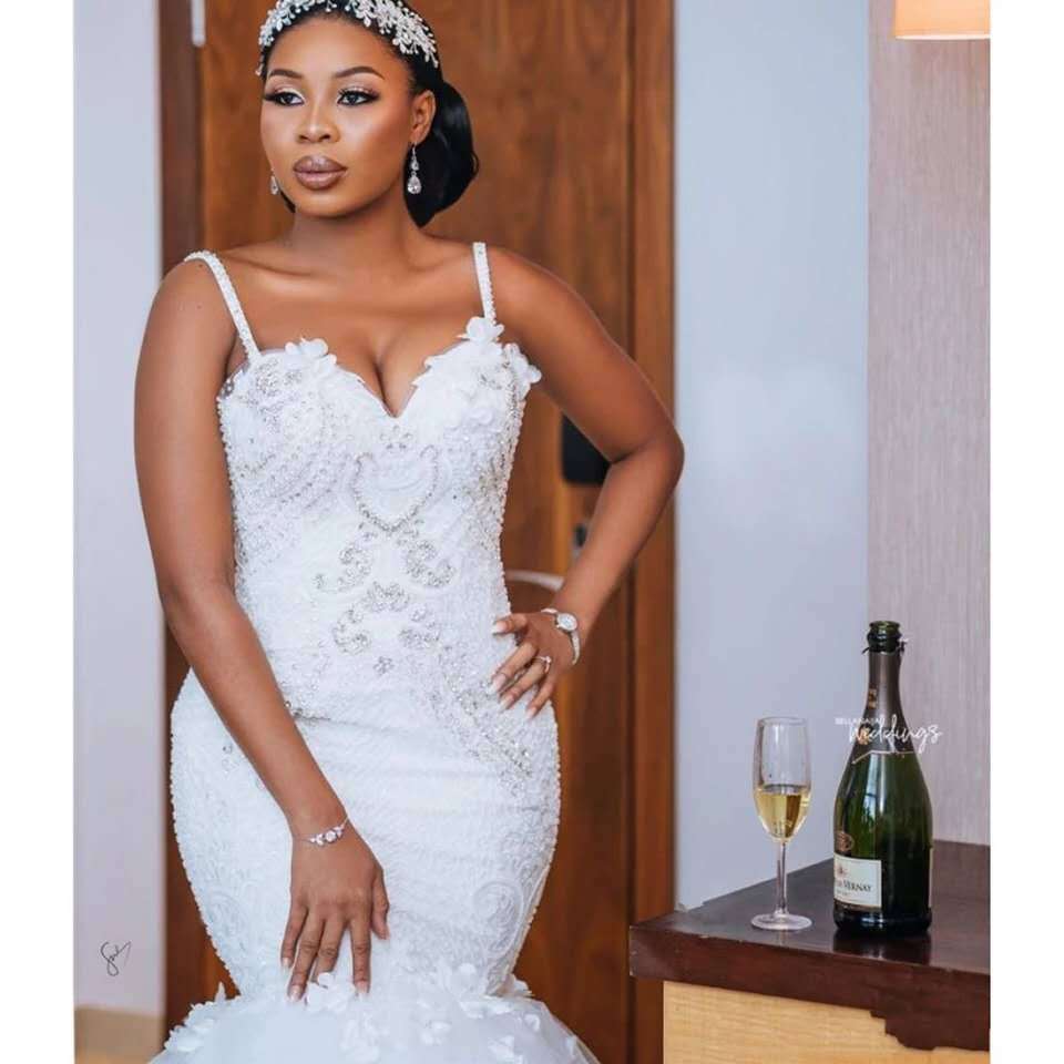 white beaded wedding gown with lace sleeveless big tail detailing and fitted silhouette made from lace sleeveless big main fabric in an african mermaid style