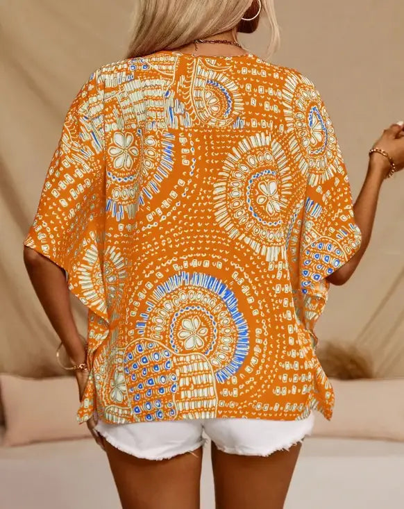 Orange bohemian-patterned kaftan with white and blue intricate designs featuring a style batwing sleeve ideal for vacation style batwing wear.