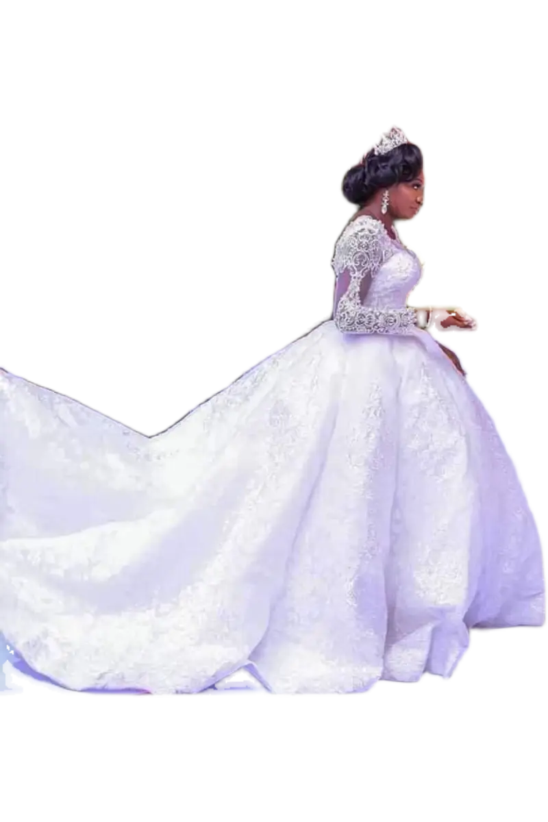 A woman wearing an elegant white lace African wedding dress with long sleeves and a voluminous embroidered skirt.