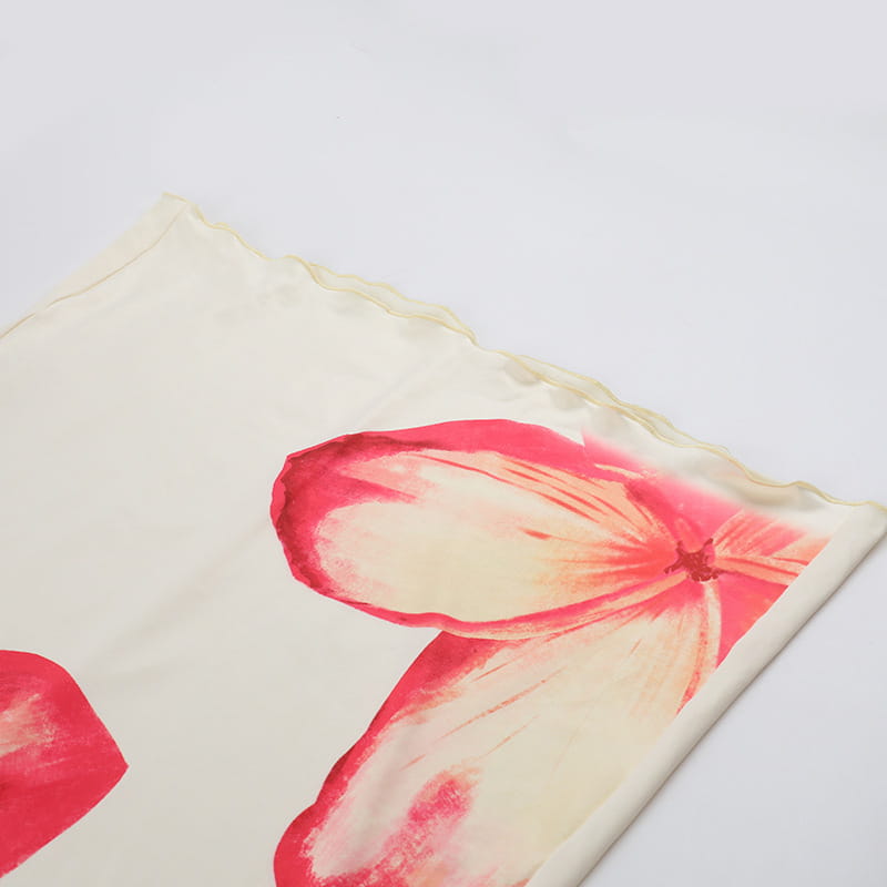 a delicate cream-colored silk scarf with an elegant slim print featuring a vibrant pink and red floral design complements the elegant slim print floral top and skirt set