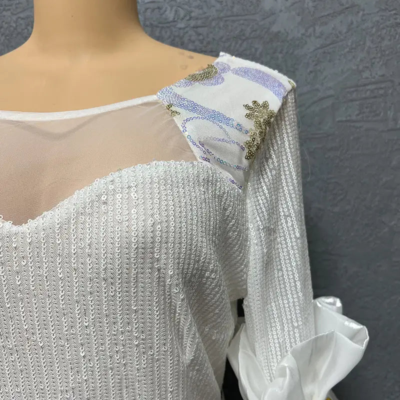 White sequined half sleeve slim fit floral evening dress with round neck shirt design features sheer mesh neckline and decorative shoulder panel with lavender stripes and gold floral embroidery.
