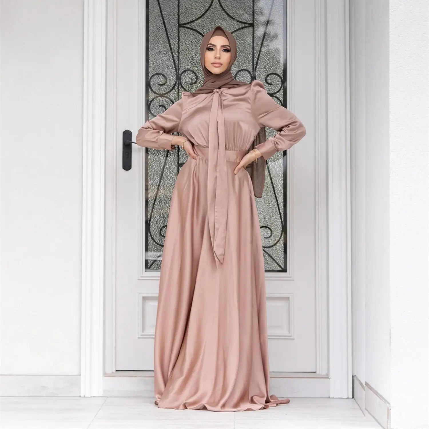 A flowing dusty rose large hem satin dress with long sleeves and a tied waistband from the large hem satin long sleeve abaya collection.