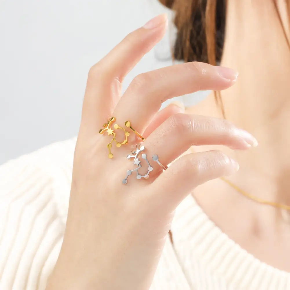 A personalized stainless steel constellation ring set featuring delicate gold and silver slender bands with intricate star and planetary designs.