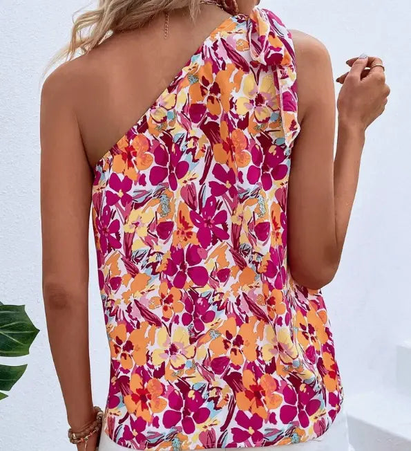 A vibrant holidaya allover floral one-shoulder blouse in pink orange and yellow featuring an allover floral print and a ruffled floral print knot neckline.