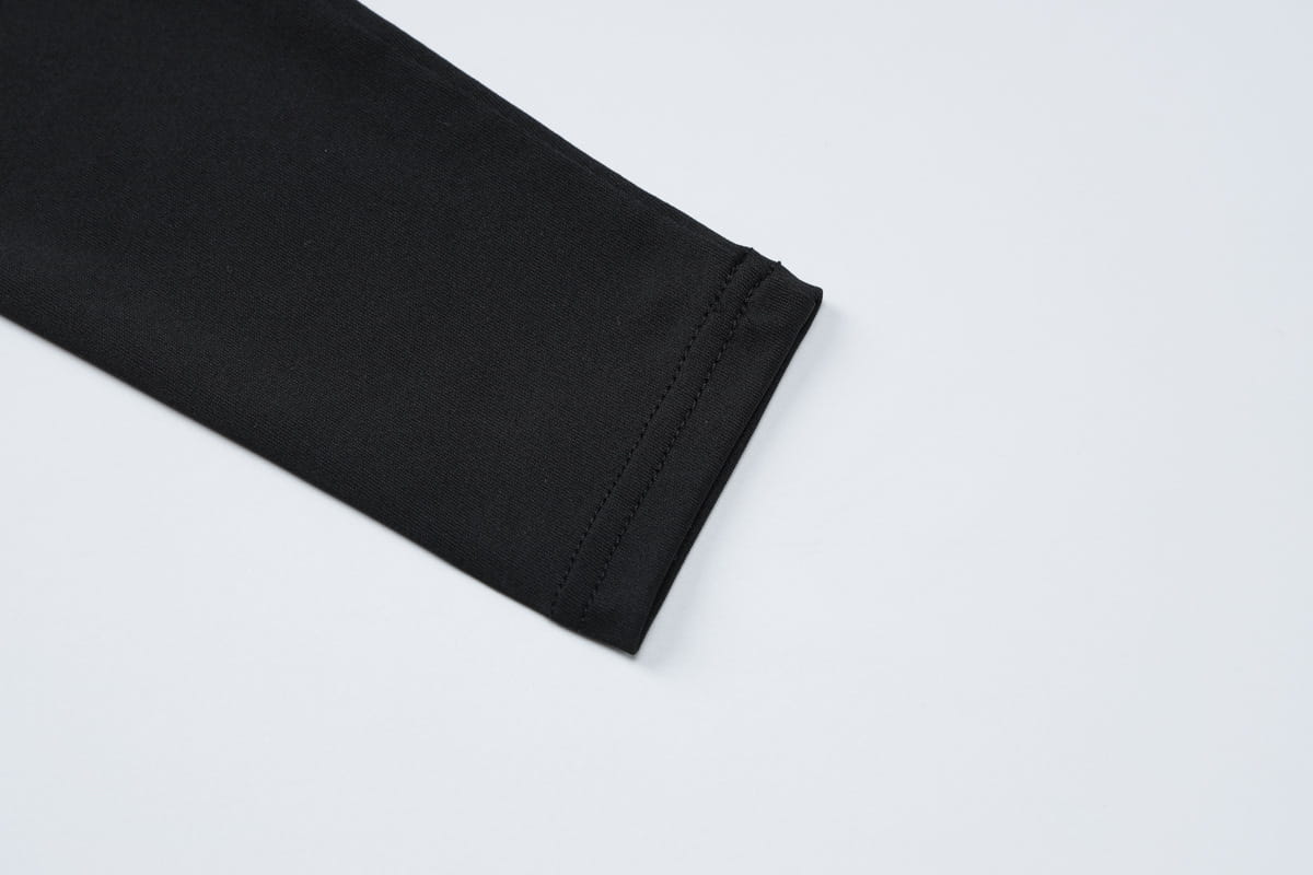 black fabric sleeve with neat uniform stitching along the cuff of a sexy hot girl long sleeve dress featuring hollow out design