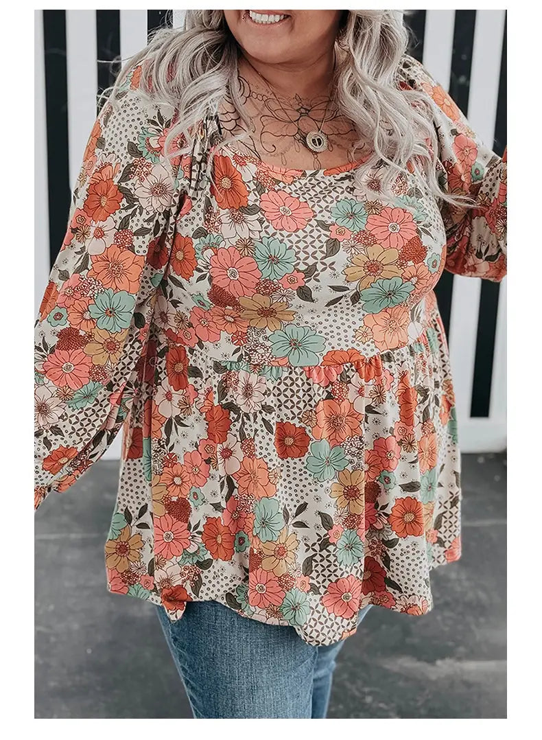 A plus size casual loose floral chiffon peplum shirt featuring long sleeves and a vibrant floral printed square pattern with orange coral and teal blossoms on a cream background.