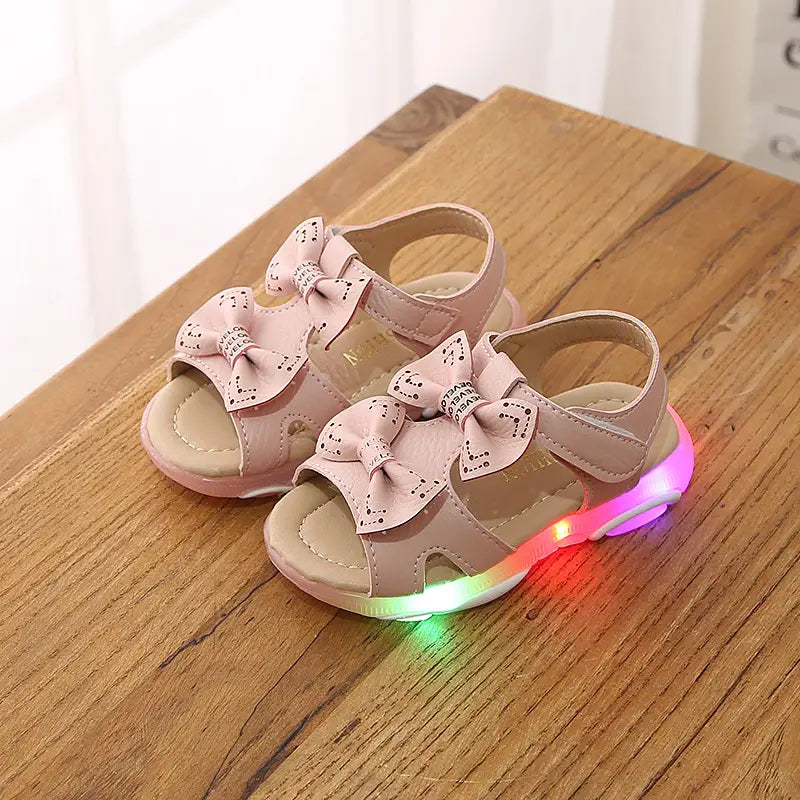 pink children’s sandals with decorative bows and white led flashing soles designed as cute flower flashing princess shoes