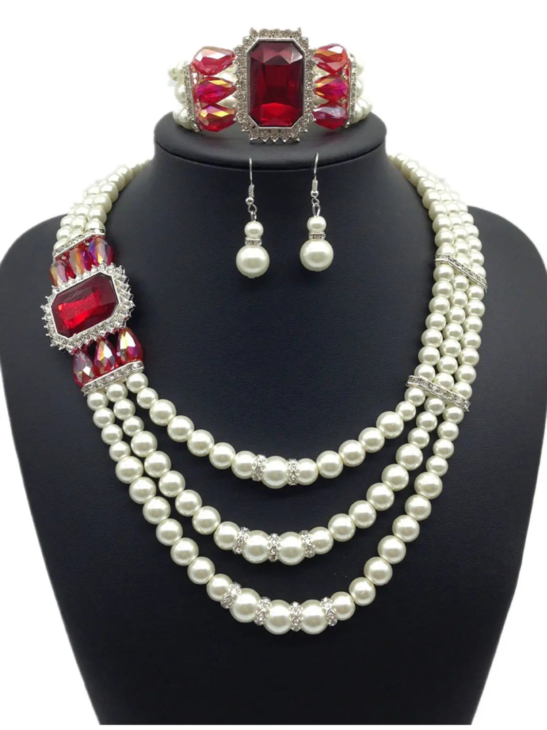 Elegant three-strand pearl necklace with bold red fashion diamond gemstone accents and silver-toned detailing in a european fashion diamond jewelry set