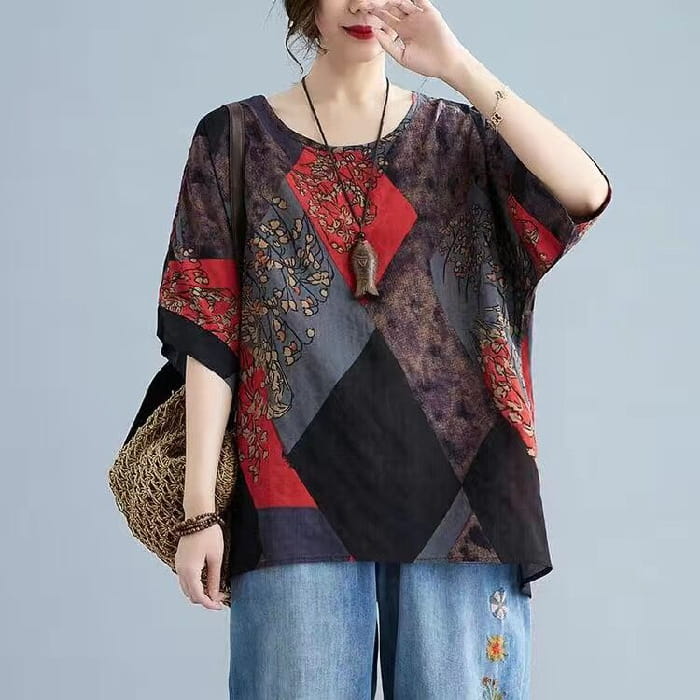 A stylish loose round neck printed patchwork blouse with short sleeves featuring bold red and black geometric panels and intricate floral embroidery on fabric.