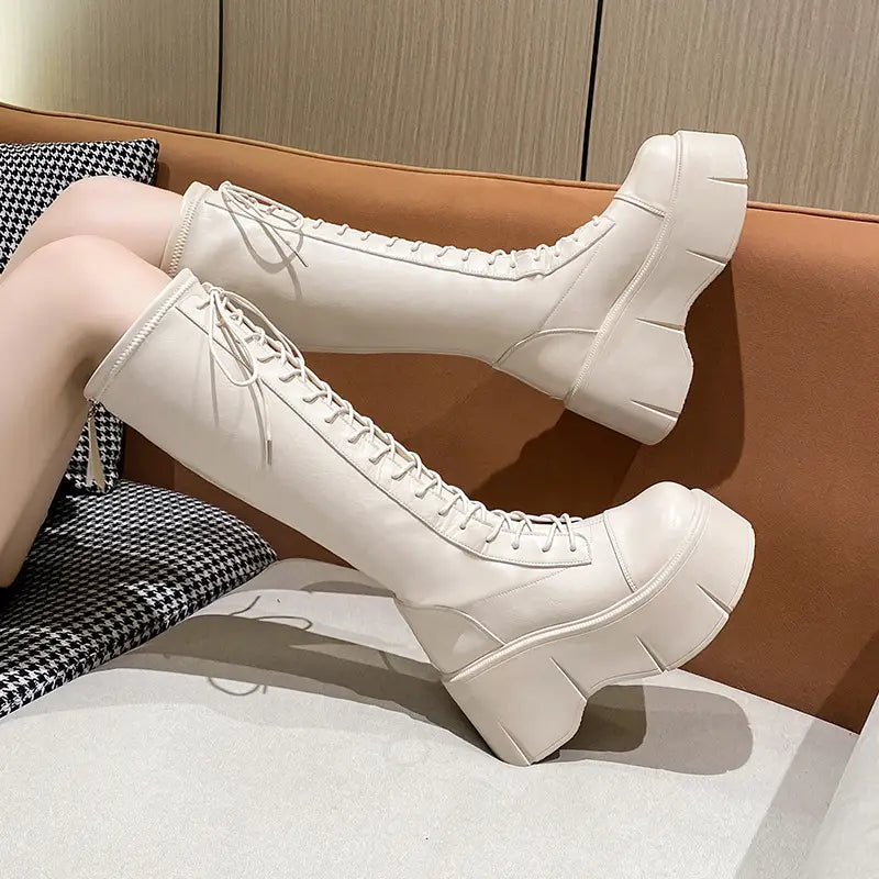 Fashion white platform knee-high boots with lace-up fronts and a glossy finish suitable for stylish footwear collections.