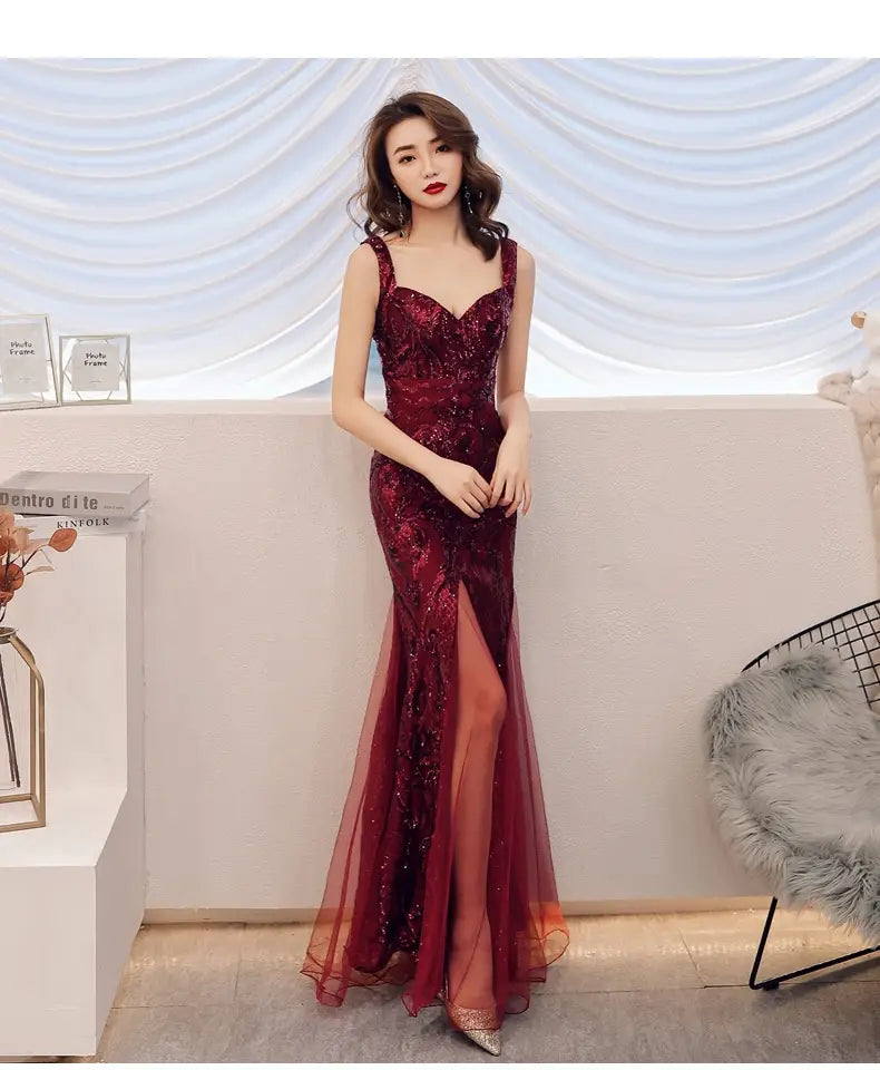 A shimmering burgundy fishtail long summer evening dress with intricate beading, sheer overlay, plunging neckline, high slit, and summer sequins sling design.