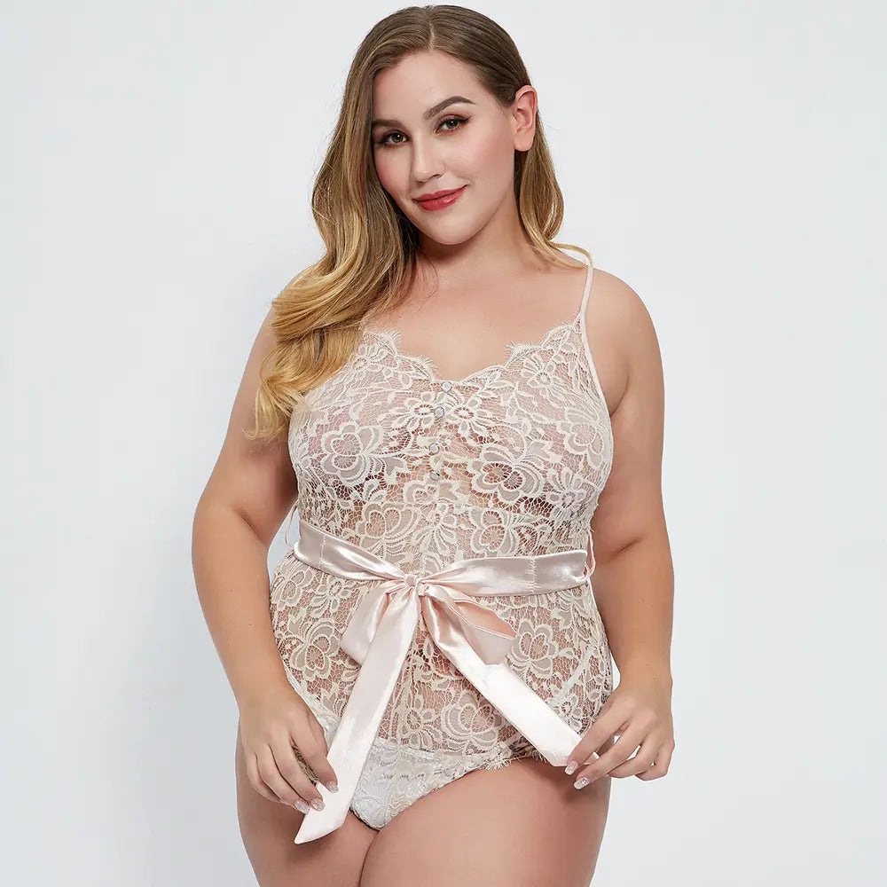 A delicate beige oversized lace lace bodysuit featuring a satin ribbon belt tied in a bow at the waist.