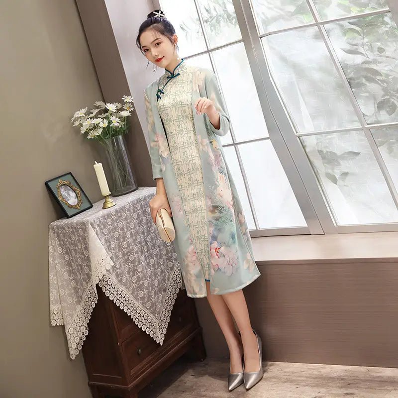 A light mint green medium length cheongsam dress featuring delicate floral embroidery, a subtle textured pattern, and traditional Chinese collar details paired with a matching jacket.