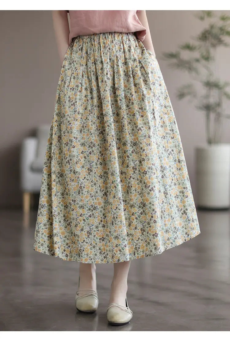 A flowing a-line midi skirt in soft cream washed cotton with delicate yellow and muted green artistic floral washed patterns.