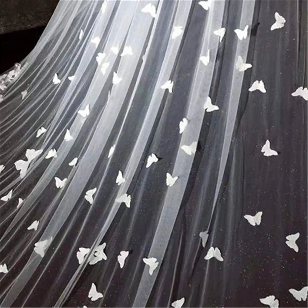 a sheer black tulle sky veil bridal wedding dress adorned with scattered white butterfly appliqués in the butterfly lace sky veil style