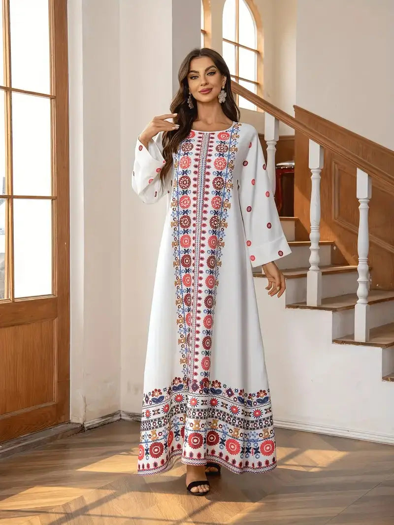 A flowing white long sleeve maxi dress featuring intricate red, blue, and gold floral print embroidery and rhinestone bead embellishments along the neckline, sleeves, and hem.