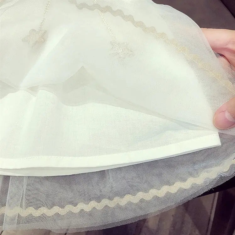 a delicate white tulle baby gauze dress summer princess dress featuring a scalloped edge and subtle embroidered details