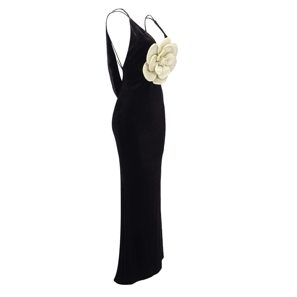 Black camisole backless slim fit velvet floral gown featuring a black velvet slip dress with thin straps and a large cream-colored floral embellishment on the shoulder.