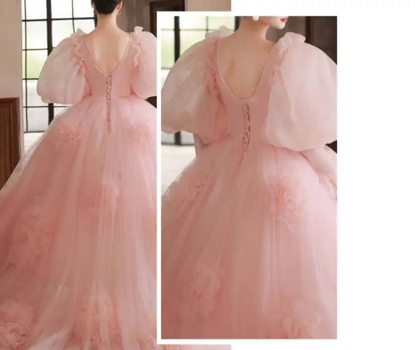 a delicate blush pink tulle gown with voluminous puffy sleeves and a deep v-back adorned with subtle embellishments shown from the back side, perfect for a high end banquet style host occasion