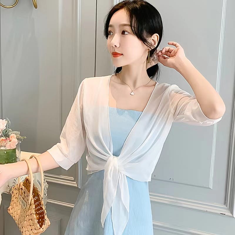 light blue chiffon short shawl summer coat styled over a square-necked dress with a sheer white cardigan tied at the front