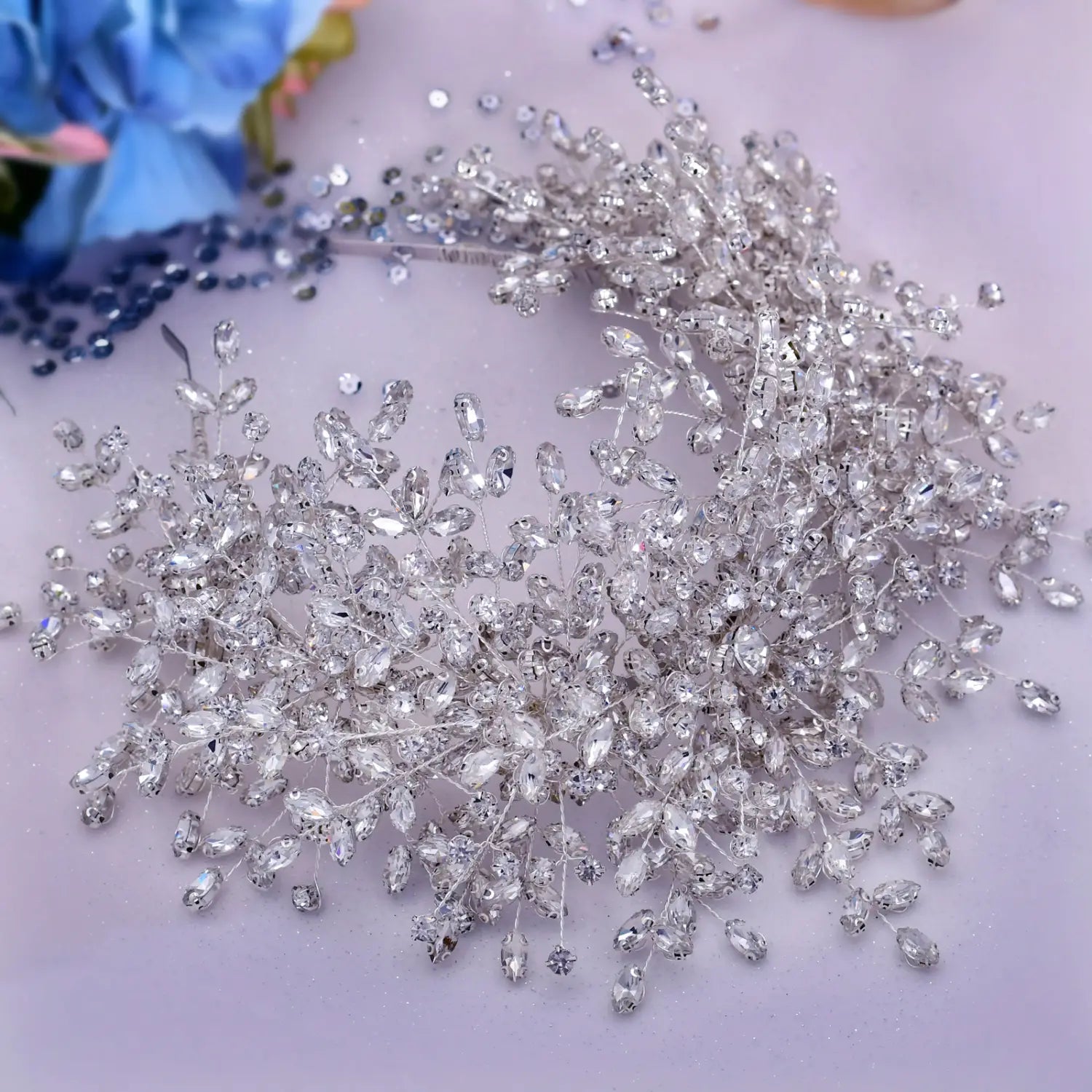 A sparkling silver crystal hair vine with numerous clear faceted rhinestones arranged in a delicate leafy design for a heavy handmade rhinestone ice and snow queen wedding crown.