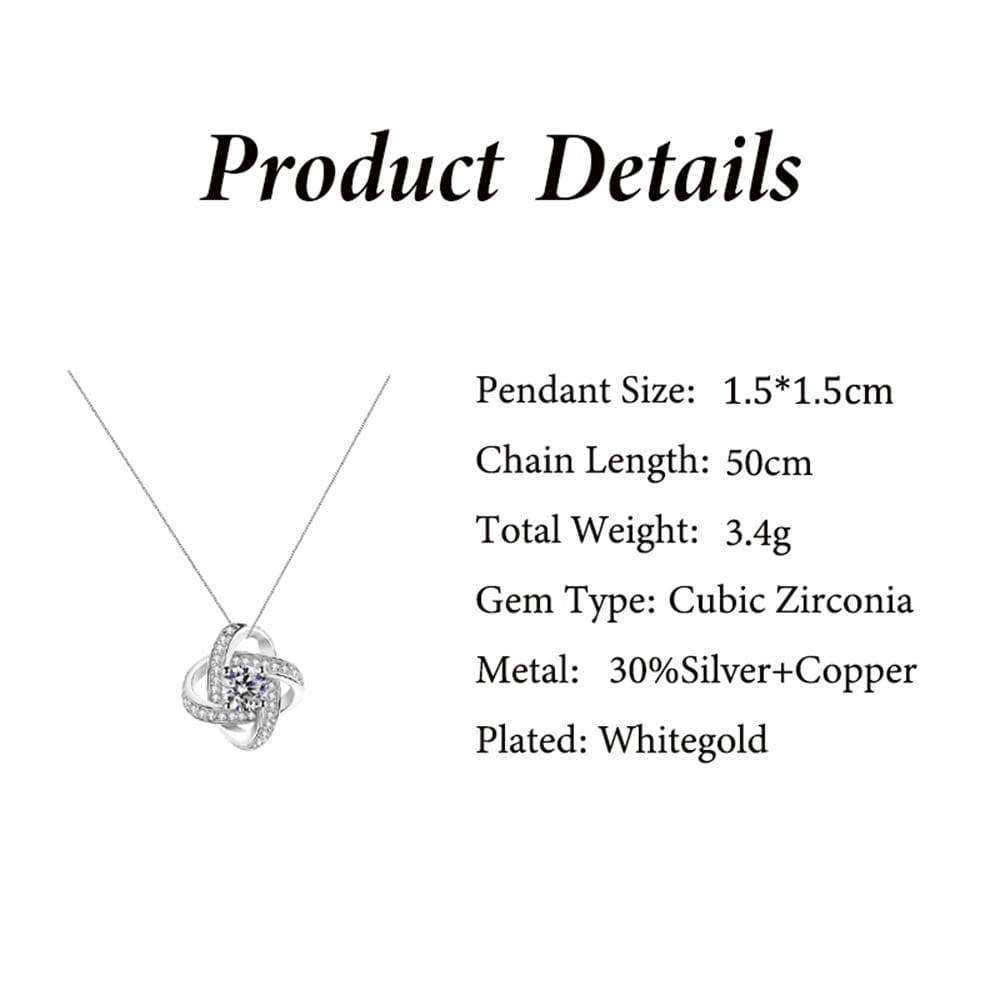 a delicate white gold-plated necklace with a swirling knot pendant adorned with cubic zirconia stones displayed in a red apple jewelry box featuring a rose