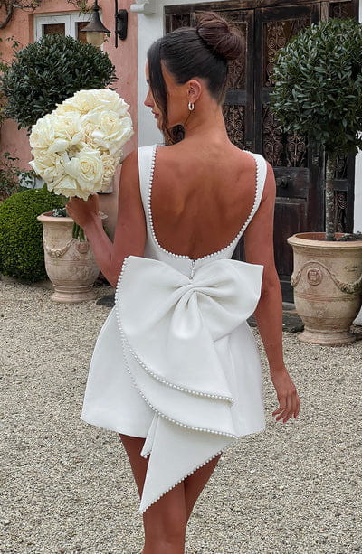 a white pearls backless dress summer slim featuring a mini design with a large back bow and beaded trim at the back