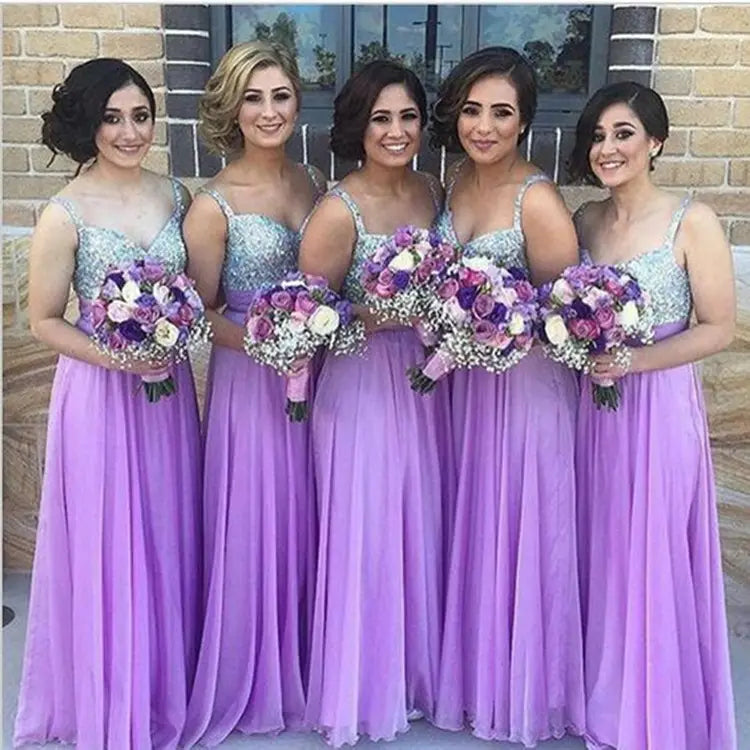 The bridesmaids are wearing matching purple sequin chiffon bridesmaid dress long gowns with sequined bodices suitable as a bff bridal gown.