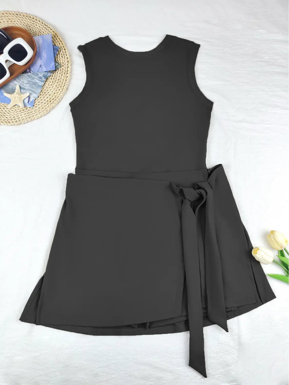 black sleeveless side slit yoga tennis skirt sport dress with fitted bodice, flared skirt, and matching fabric tie at the waist