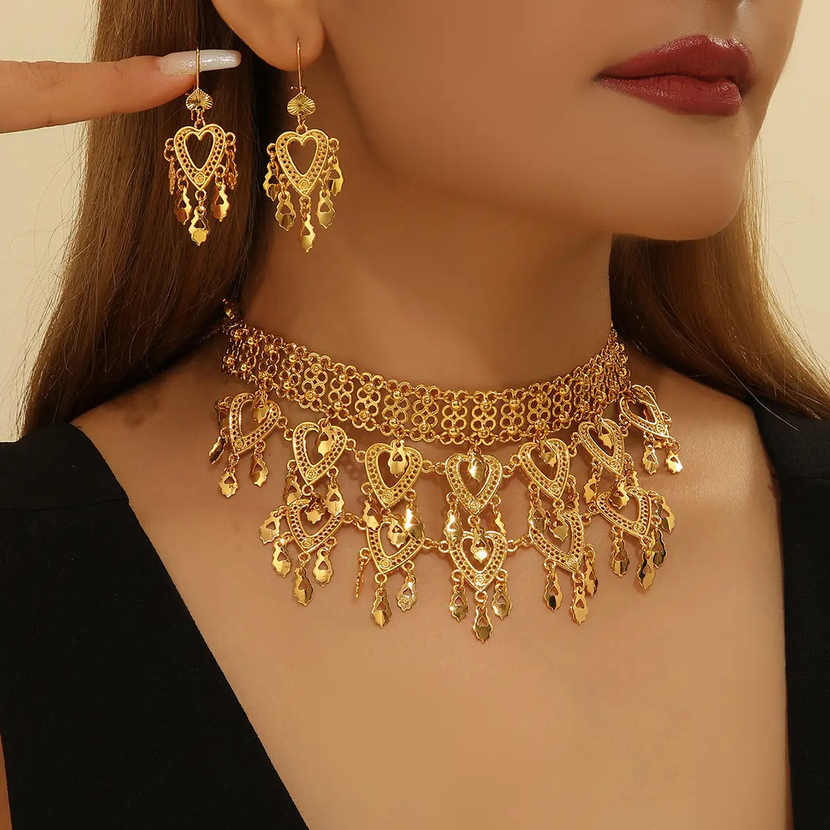 Gold heart-themed choker necklace with intricate filigree design and dangling charms from a 3pcs fashionable retro luxury hollow necklace earrings set.