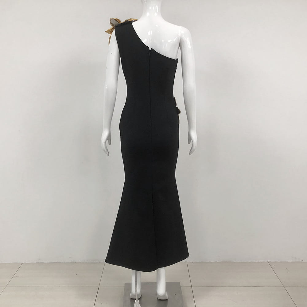 Black satin bandage golden flower maxi dress featuring a one-shoulder mermaid design with a gold bow at the shoulder and a side slit.