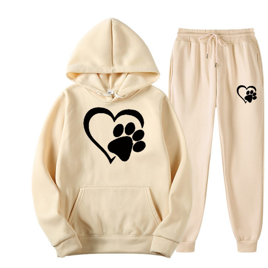 cream-colored hooded sweatshirt and matching joggers set featuring a black logo heart-and-paw print on the front of the hoodie and thigh of one leg in white heart paw printed hoodie sets.