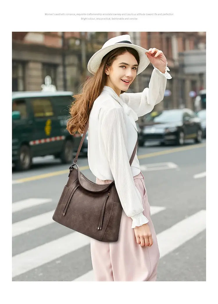 brown leather shoulder bag with large capacity and curved top zipper closures for luxury women leather handbag use