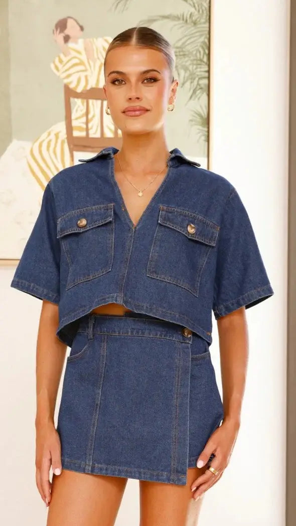 Blue denim short sleeve loose cropped shirt with two front pockets featured in a women’s irregular denim short pantskirt suit.