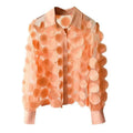 A delicate peach-colored chiffon flower chiffon gauzy shirt featuring layered circular appliqués in orange and cream tones