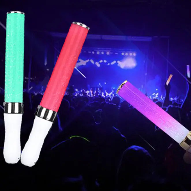 three glowing glow stick fluorescent lights in green red and purple with white grips and metallic silver ends displayed as two white led glow stick lights with wrist straps