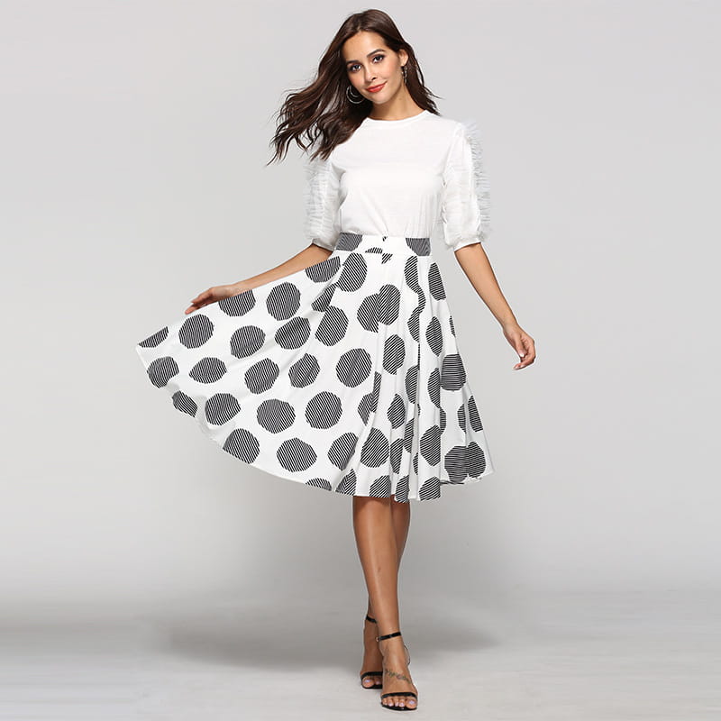 a white and black large polka dot round slim fit a-line skirt with a flared silhouette featuring bold circular patterns filled with fine horizontal stripes