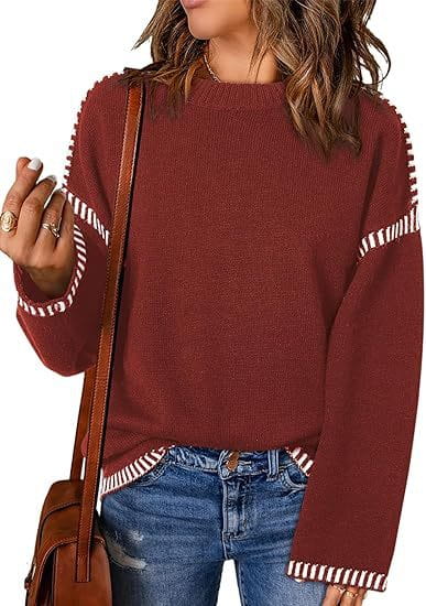A cozy maroon solid round neck pullover knit sweater with white striped accents along the sleeves and hem.