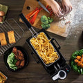 Black 3l electric french fries fryer with metal basket filled with golden french fries for deep frying use
