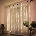 A delicate white sheer curtain with vertical warm glowing fairy lights in usb metallic christmas curtain lights 300 led