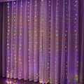 A 3m x 3m usb metallic christmas curtain featuring sheer translucent fabric with vertical strings of colorful led lights