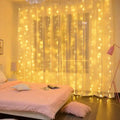 Warm yellow usb metallic christmas curtain lights draped over a sheer curtain in a 3m x 3m design with 300 leds