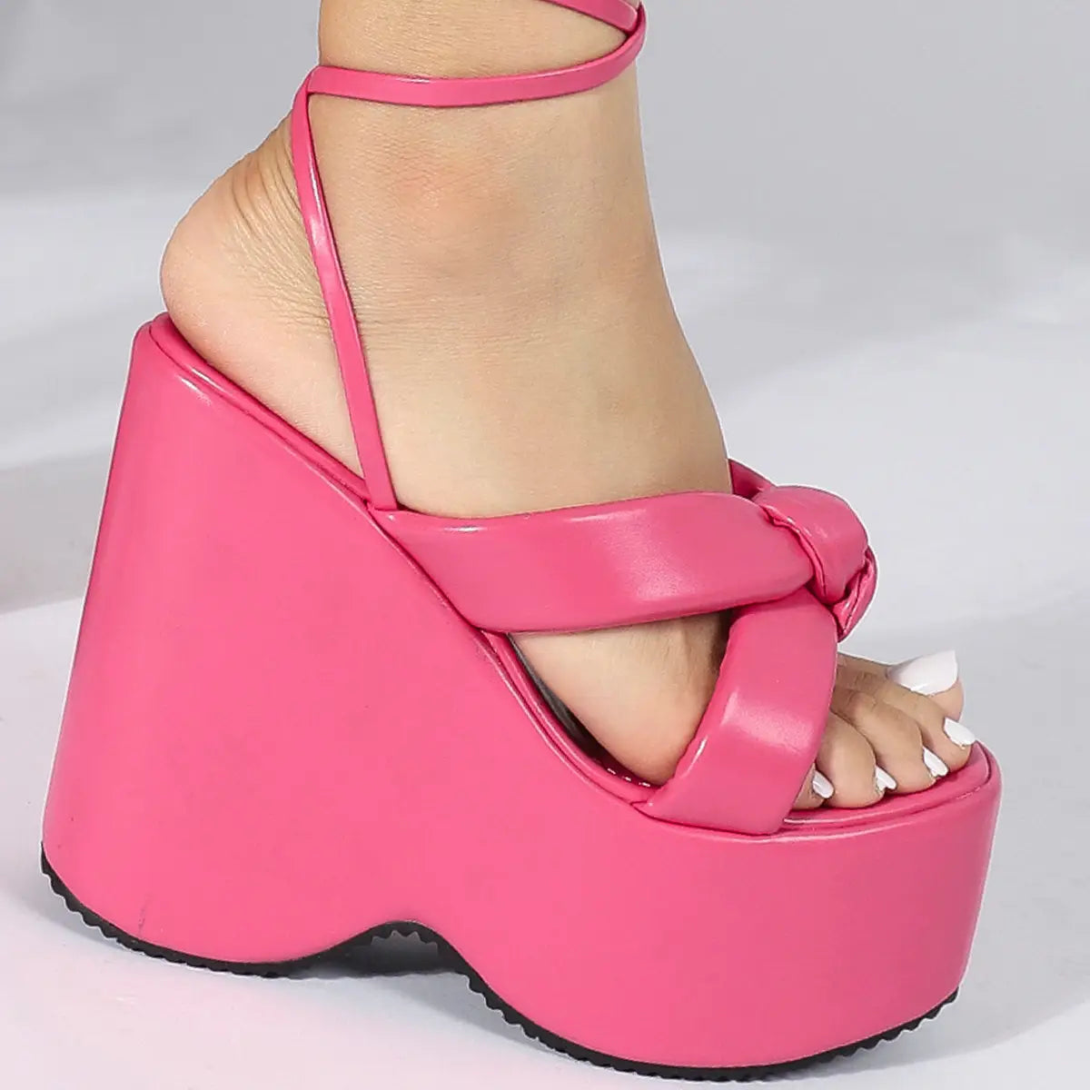 Bright pink platform wedge high sandal with glossy patent leather straps and a thick chunky sole for a stylish high heel platform look.